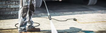 All 1 Service technician performing commercial pressure washing as part of a facility maintenance program for an industrial or commercial property.